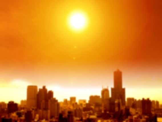 the sun casting an orange glow over a blurry city skyline