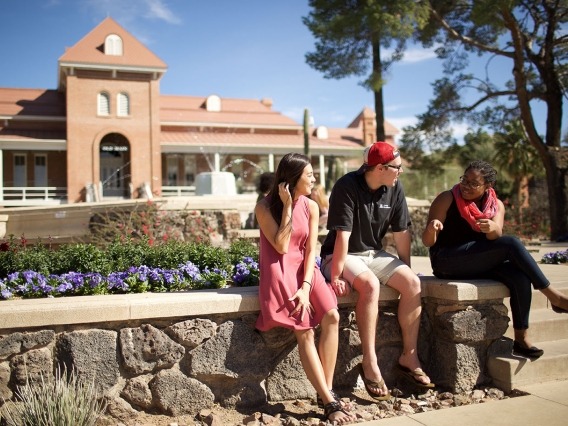 three students sitting in front of Old Main