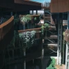 Interior view of the ENR2 Building’s canyon-like courtyard, with rust-colored fins, open-air walkways, and terraces covered in hanging vines and greenery.